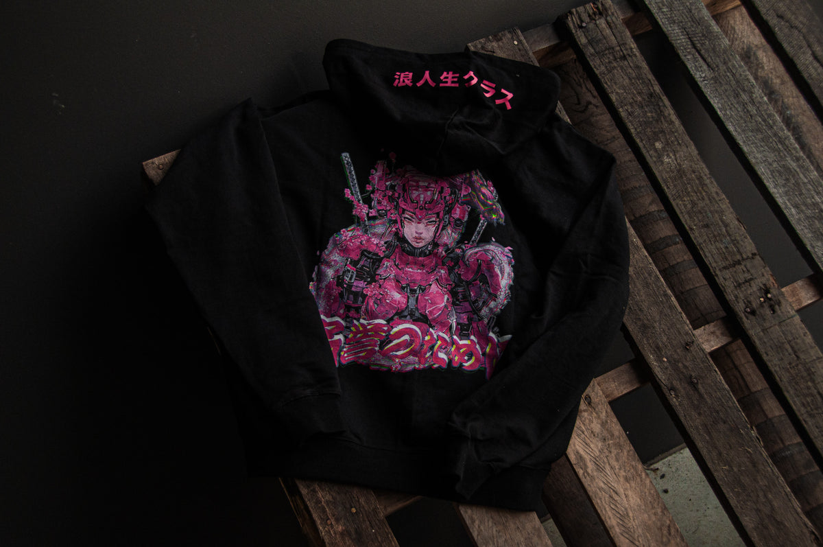 The Mecha Geisha oversized hoodie from the Ronin Class Collection by Incompletegl features a striking neon pink graphic of an armored figure wielding two swords. Japanese characters embellish both the hood and design. Displayed flat on wooden pallets against a dark backdrop, it perfectly encapsulates a cyberpunk aesthetic.