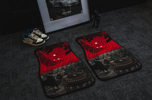 Two car floor mats exhibiting a red and black dragon motif lie on a dark carpet. Beside them, a pair of sneakers and a framed black-and-white car photograph are displayed, accompanied by a small figurine from the Naruto Mystery Pack! anime bundle by Incompletegl.