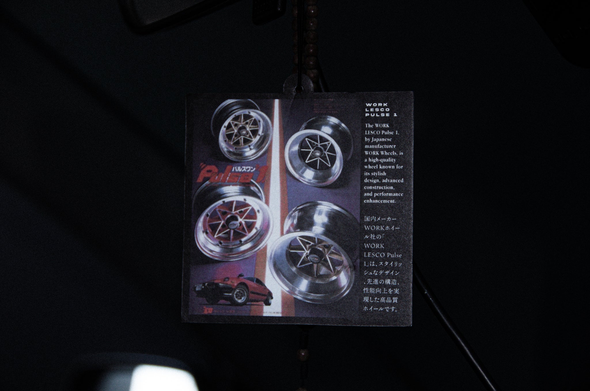 The image depicts an automotive advertisement pamphlet hanging, showcasing the Work Pulse1! air freshener by Incompletegl. Celebrating JDM culture, a partial view of a car is visible at the bottom left, enhanced with these stylish accessories. The text is in Japanese.