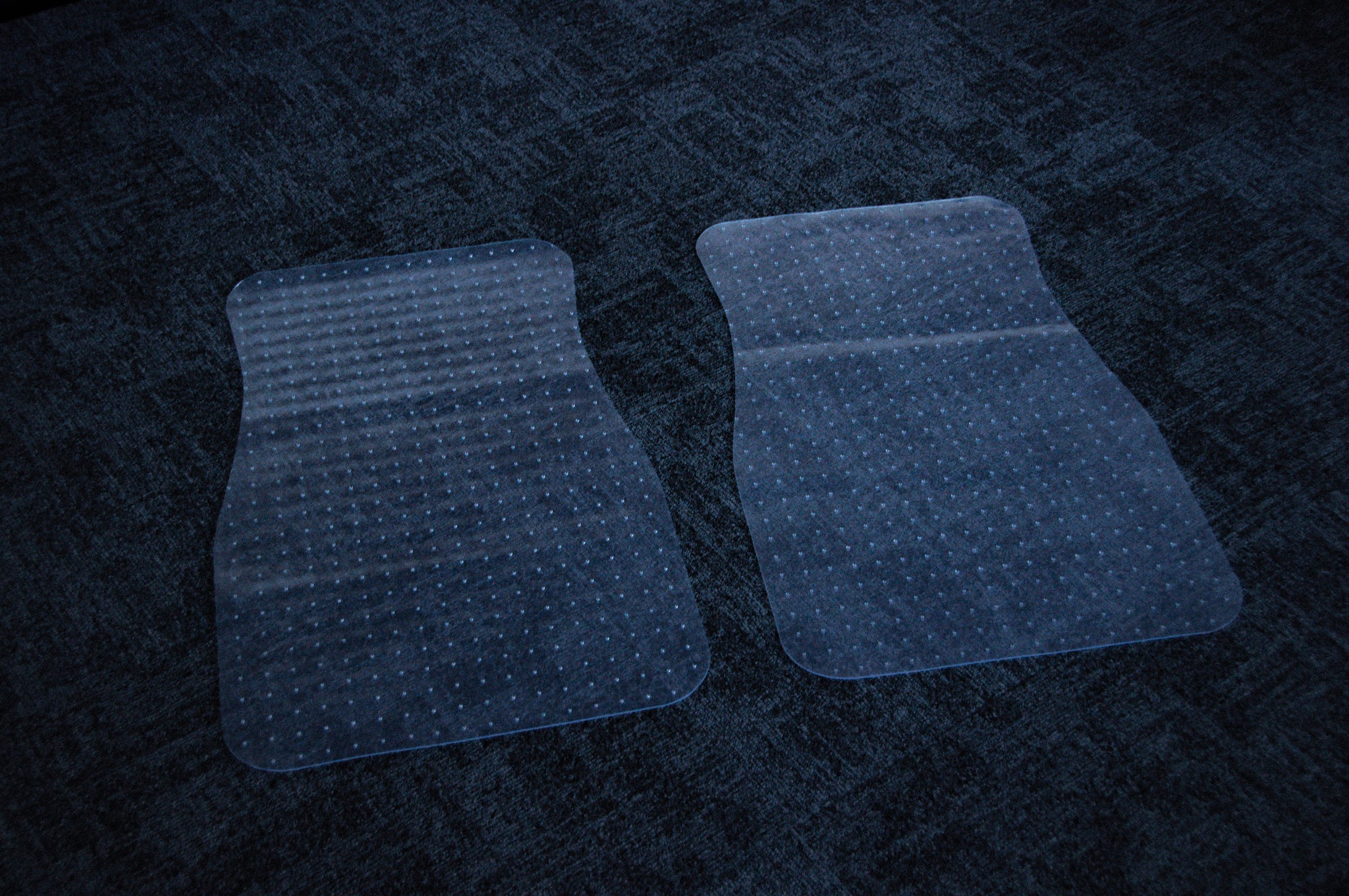 Two *Floor Mat Protection! | PVC Floor Mats!* by *Incompletegl* are placed on a dark grey carpeted floor. The mats are slightly curved and feature small, raised dots for grip. They protect the carpet and provide a smooth surface for chair movement.