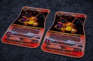 Two Pokémon trading cards featuring Charizard are displayed on a sleek grey surface, possibly resembling a stylish Charizard!! floor mat by Incompletegl. The cards are slightly curved and illustrate Charizard with stats and abilities listed beneath the image. Each card features a vibrant red and yellow design with "Charizard" written at the top, making them perfect for Pokémon enthusiasts.