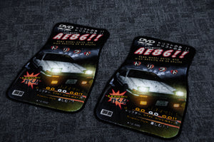 Two car floor mats from Incompletegl's Initial D; Retro Style!! collection, placed on a gray surface, each showcasing a design with Japanese text and a white AE86 with headlights on, accompanied by bold red and yellow text. Reflecting JDM culture, the mats have a rectangular base with an irregular top shape.