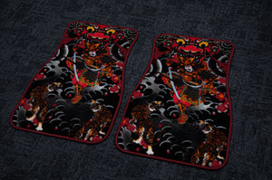 Two car floor mats from Incompletegl's "Samurai Tattoo Style! | Floor Mats!" collection lay on a dark surface. The mats feature motifs of tigers and dragons, reminiscent of traditional Japanese tattoos, with intricate patterns and vivid colors like red, orange, and black. The symmetrical designs showcase dynamic artistry deeply rooted in the symbolism of Japanese culture.