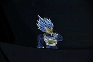 An Incompletegl Dragon Ball Z Super Pack! sticker featuring a muscular anime character with spiky blue hair is placed on a dark vehicle's window. Channeling that Saiyan spirit, the character, dressed in a white and blue battle suit, has one hand up to his forehead. The dark background enhances the sticker's visibility from the Dragon Ball Z Super Pack! Bundle.