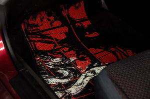 In the vehicle’s footwell area, the Chaos Red Checkered! | Floor Mats by Incompletegl, featuring a traditional Japanese dragon design, are displayed. The mat, with its black background and intricate red and white dragon depiction, seamlessly integrates traditional Japanese art into your ride. The surrounding interior of the car includes part of the seat and the car's floor.