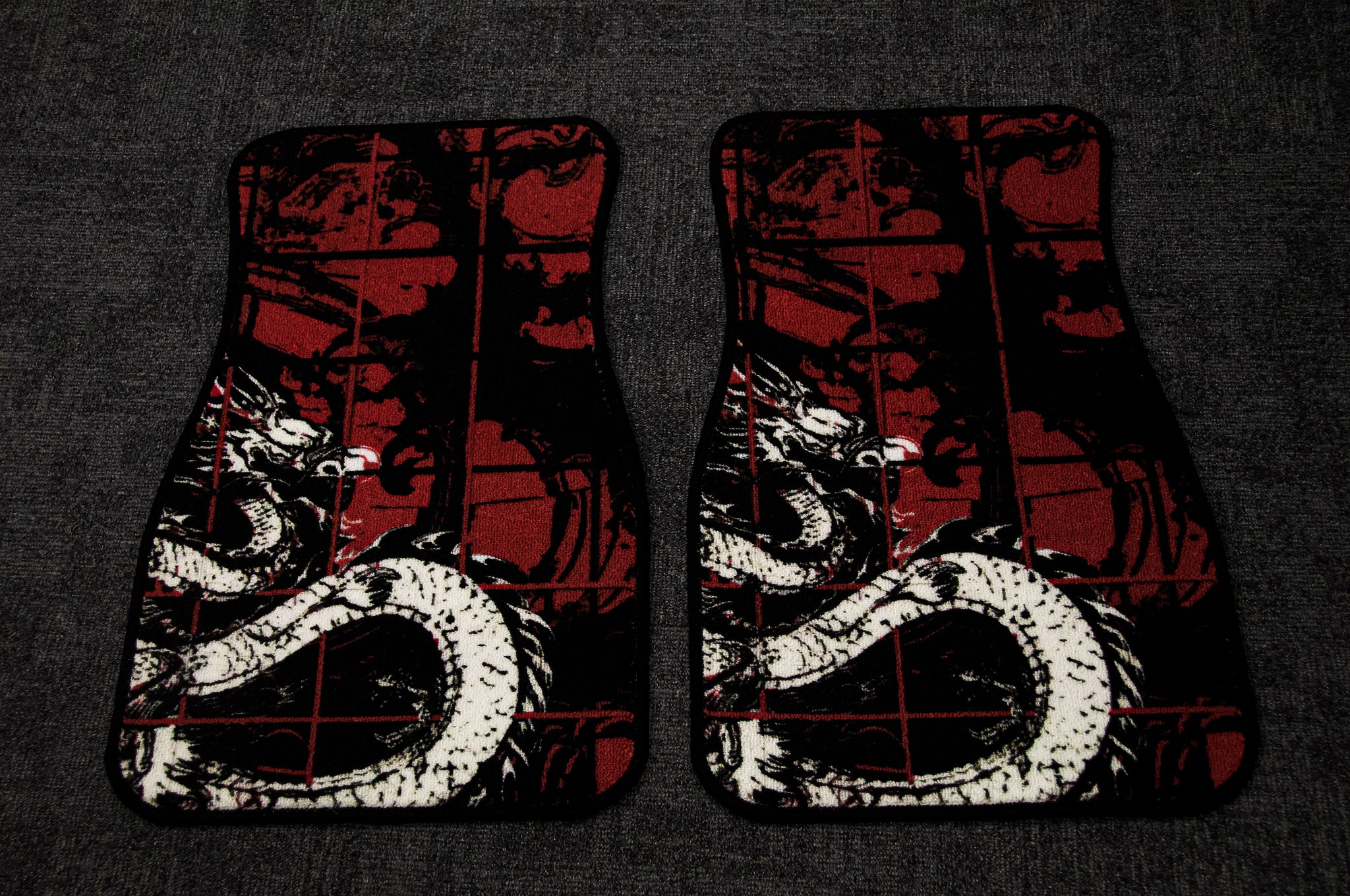 Two Chaos Red Checkered! Floor Mats by Incompletegl are displayed on a dark grey surface, featuring an illustrated white Japanese dragon with red accents set against a black and red checkered pattern. The design beautifully blends traditional Japanese art elements with modern aesthetics.