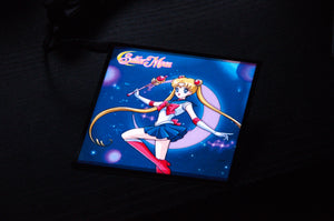 An image of the Sailor Moon! Glow Panel, a square display from Incompletegl, featuring the famous anime character Sailor Moon posed in a fighting stance against a cosmic background with the text "Sailor Moon" at the top. She is dressed in her iconic sailor outfit and holding a magical staff. This panel is an ideal JDM accessory for fans and collectors alike.