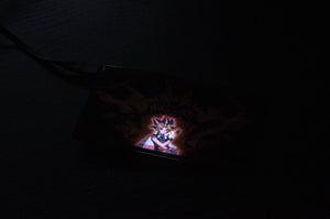 A dimly lit image showcases the Exodia! | Glow Panel by Incompletegl, featuring an anime-style character with spiky hair, reminiscent of the Yu-Gi-Oh! series, illuminated against a dark background. The panel is connected to a cable, giving it a distinct JDM accessory vibe.