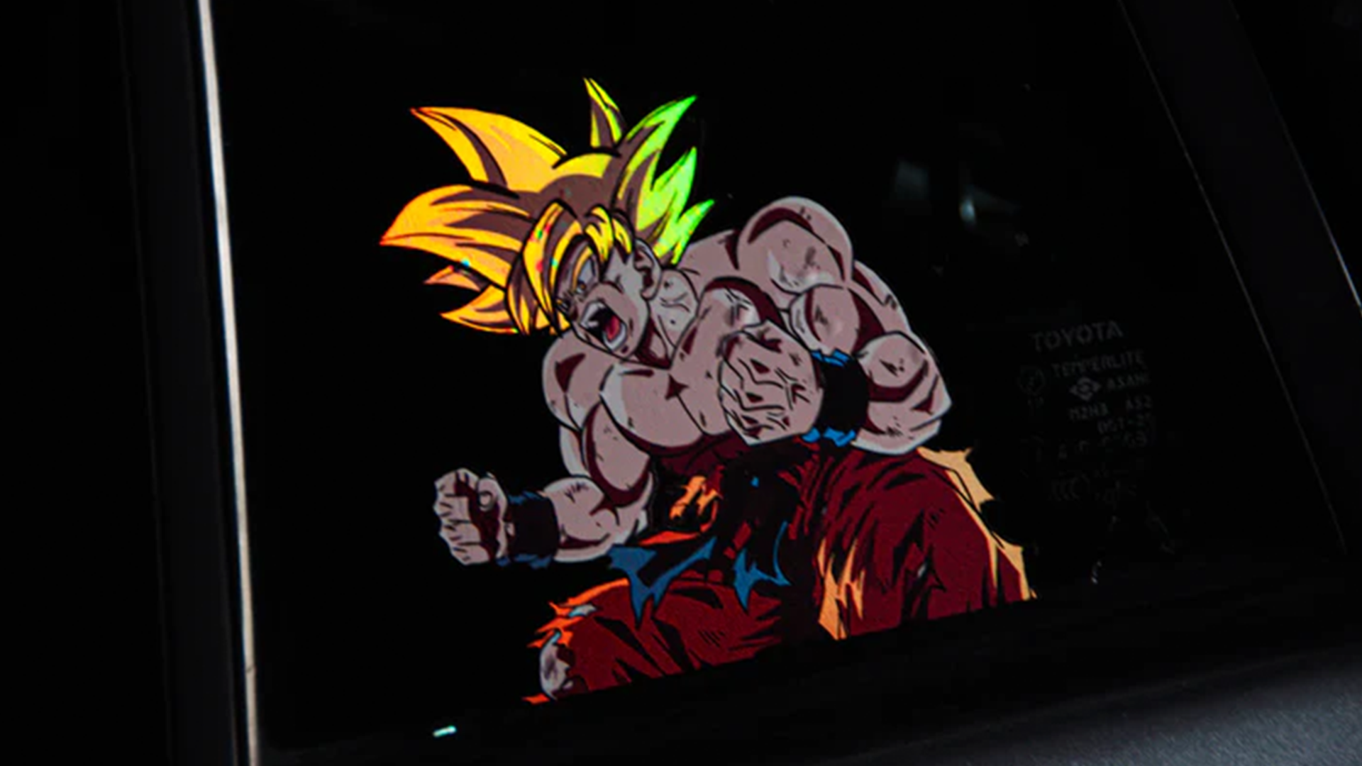 An animated character from the Dragon Ball Z Super Pack! | Bundle Pack by Incompletegl, featuring spiky yellow hair and embodying the Saiyan spirit, has a muscular build and dons a red and blue outfit. The character appears in an intense battle stance, illuminated against a dark background, with a fierce expression and tightly clenched fists.