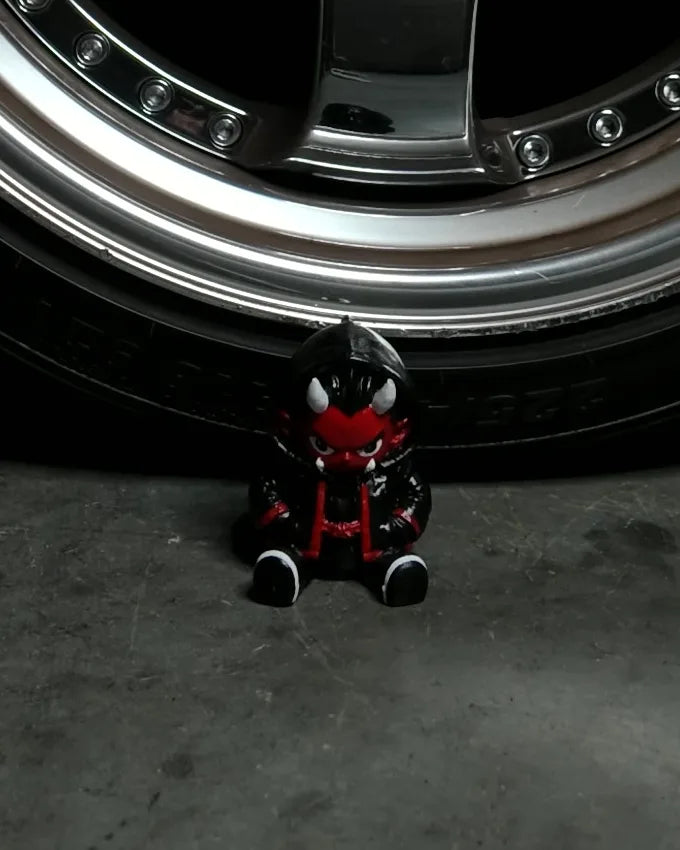Hand-painted Oni figure in front of an S15 wheel
